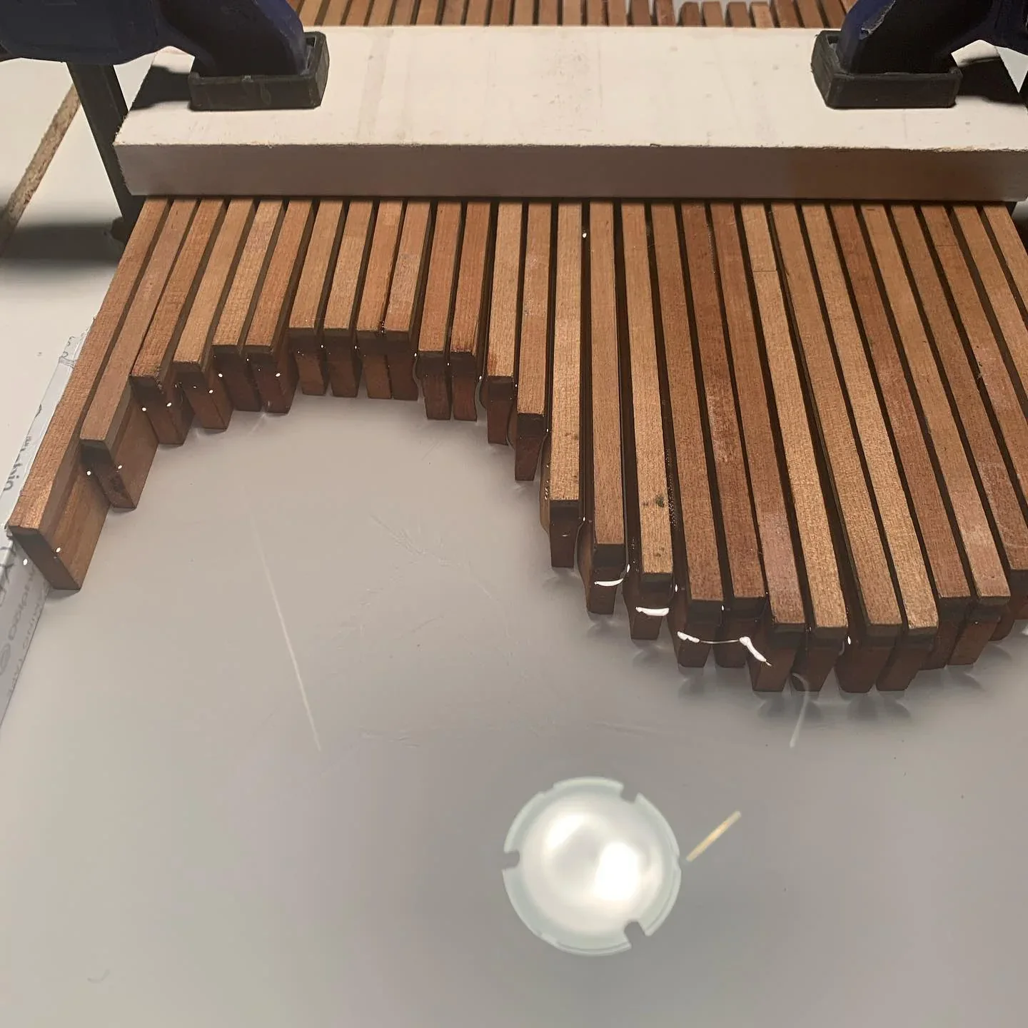 Detail of a tabletop combining birch slats and translucent resin.