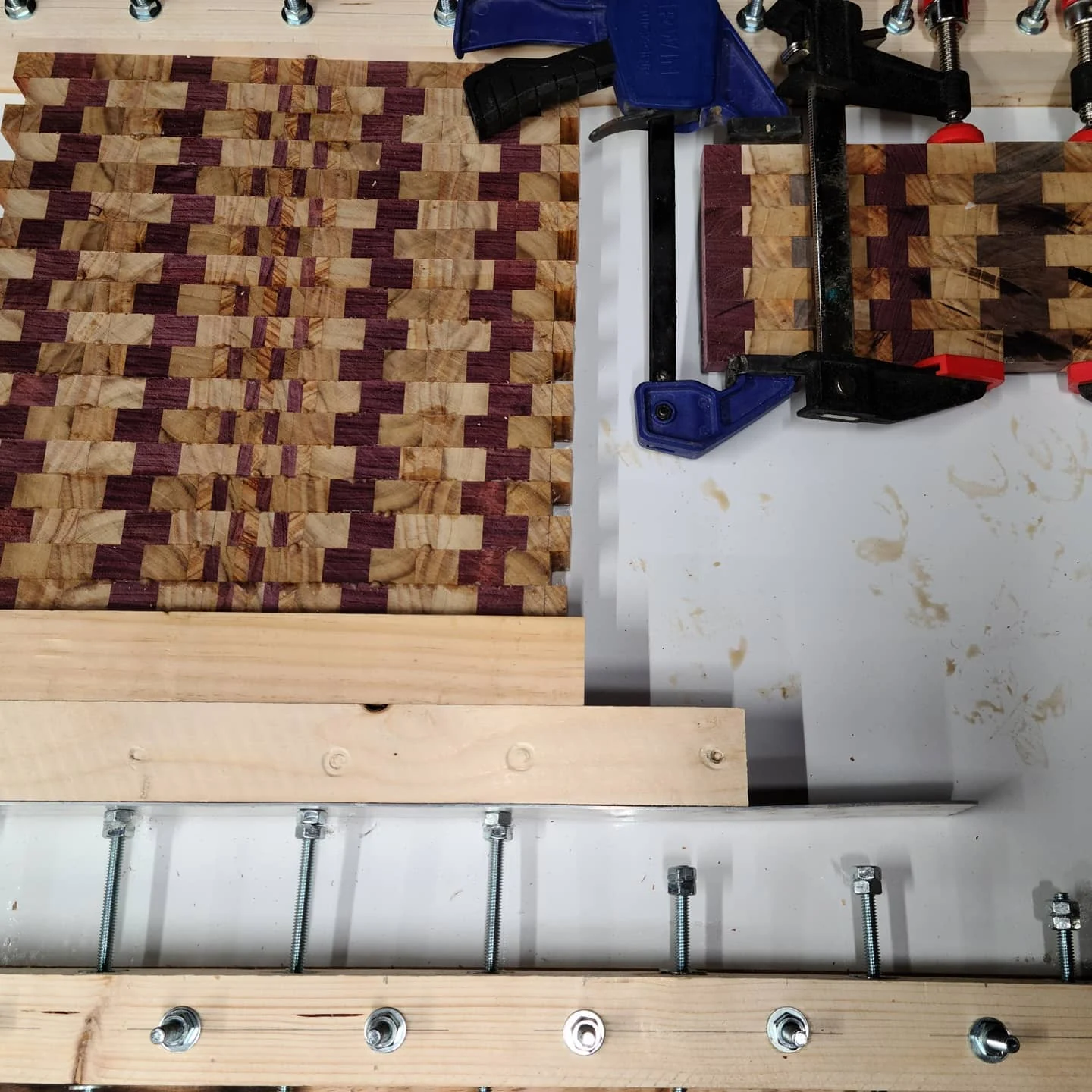 A patterned cutting-board assembly held in the shop-made clamping fixture.