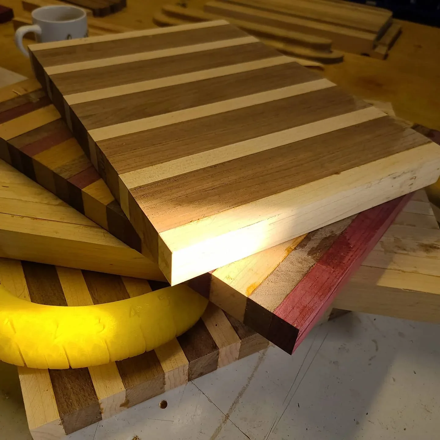 Striped and end-grain cutting boards with contrasting wood colors.