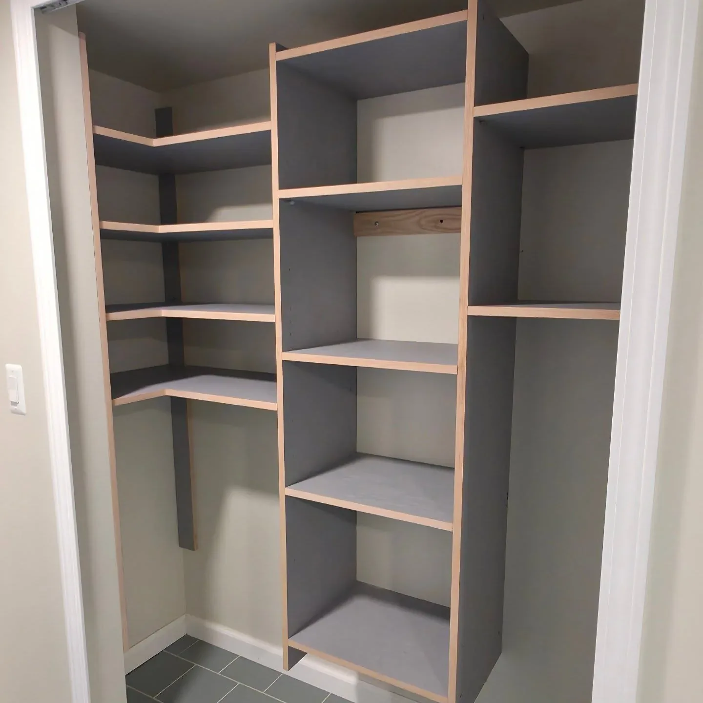 Built-in shelving with dark surfaces and contrasting wood edges.