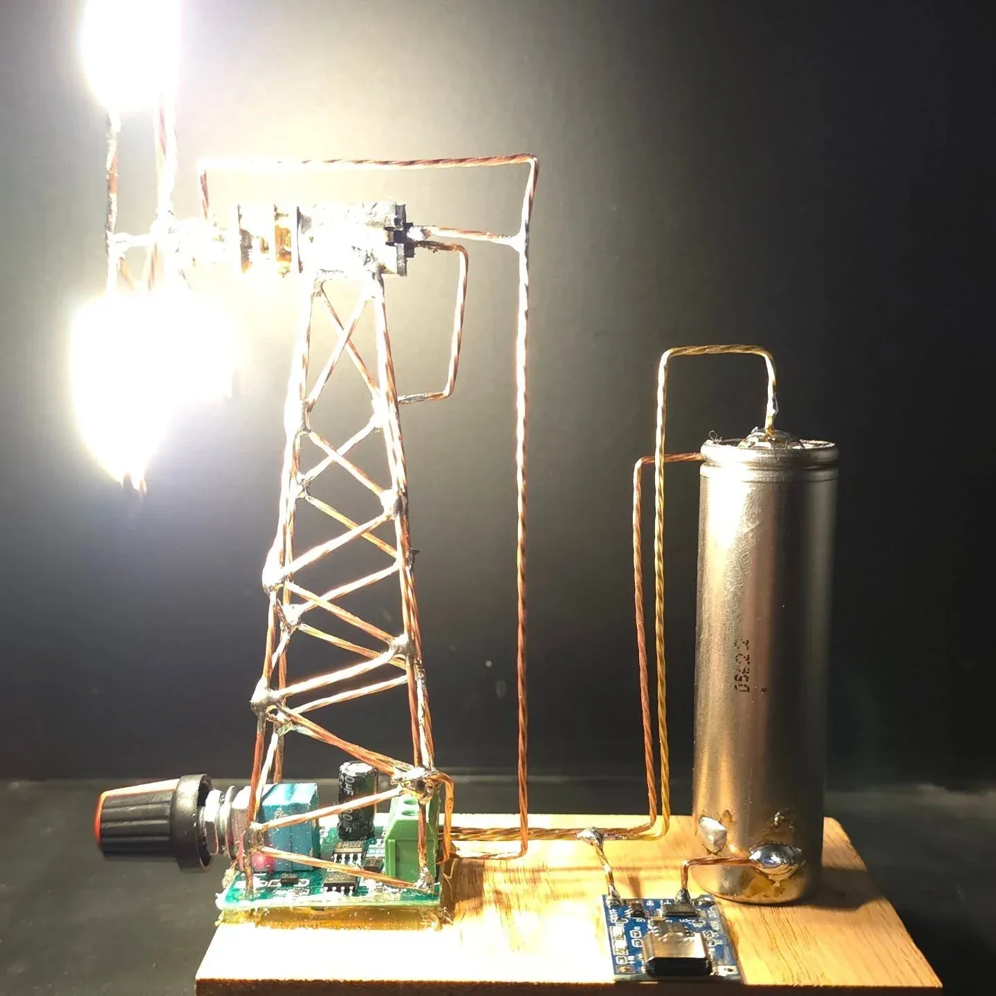 Side view showing the sculpture, cylindrical component and wooden base.