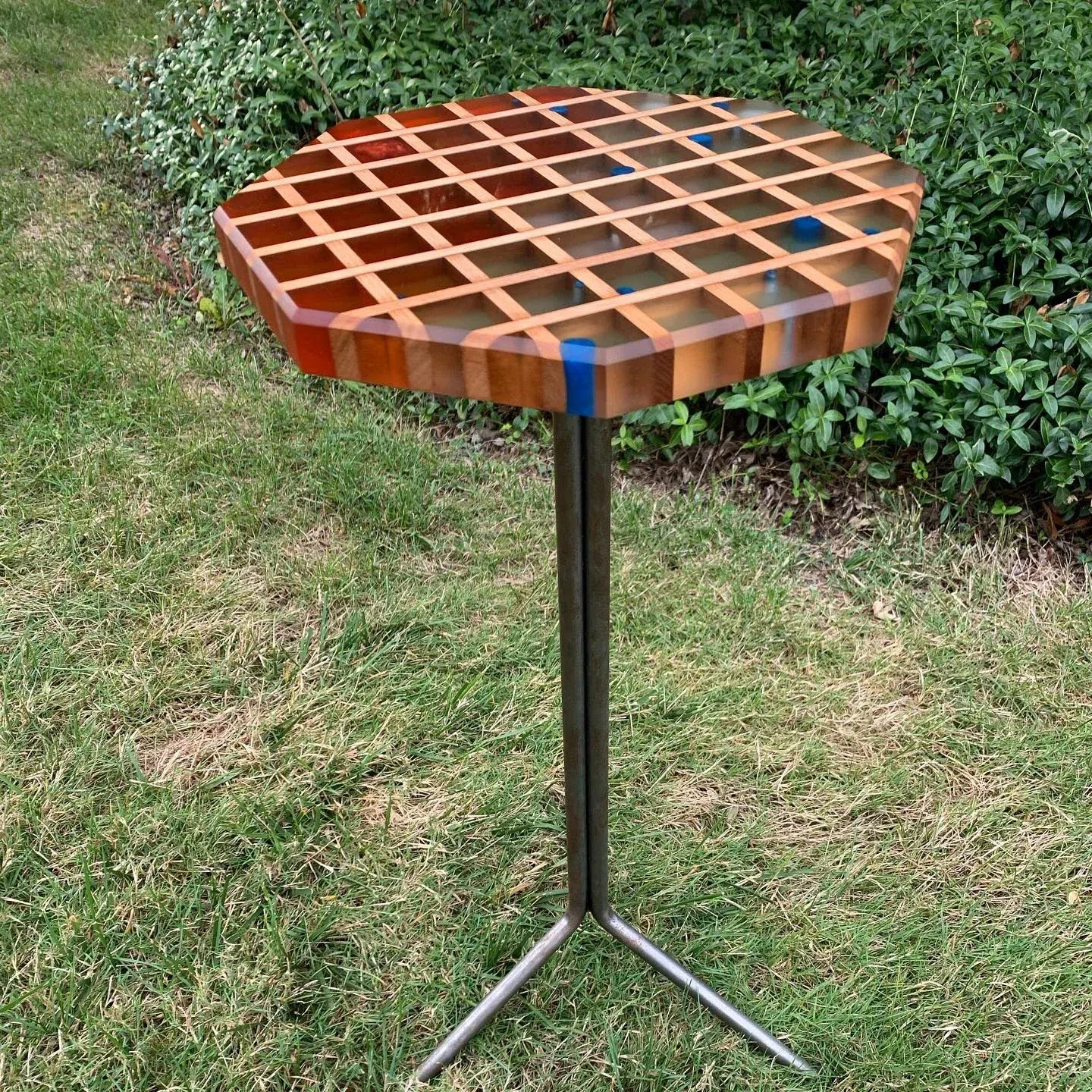 Lattice-pattern wood and resin martini table on a black tripod base.
