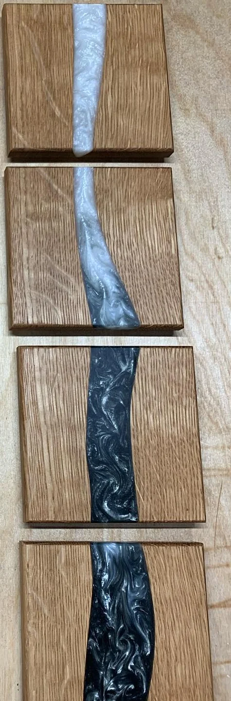 Rectangular quarter-sawn oak coasters with a narrow, light-blue resin feature. Crop of the original grouped photograph.