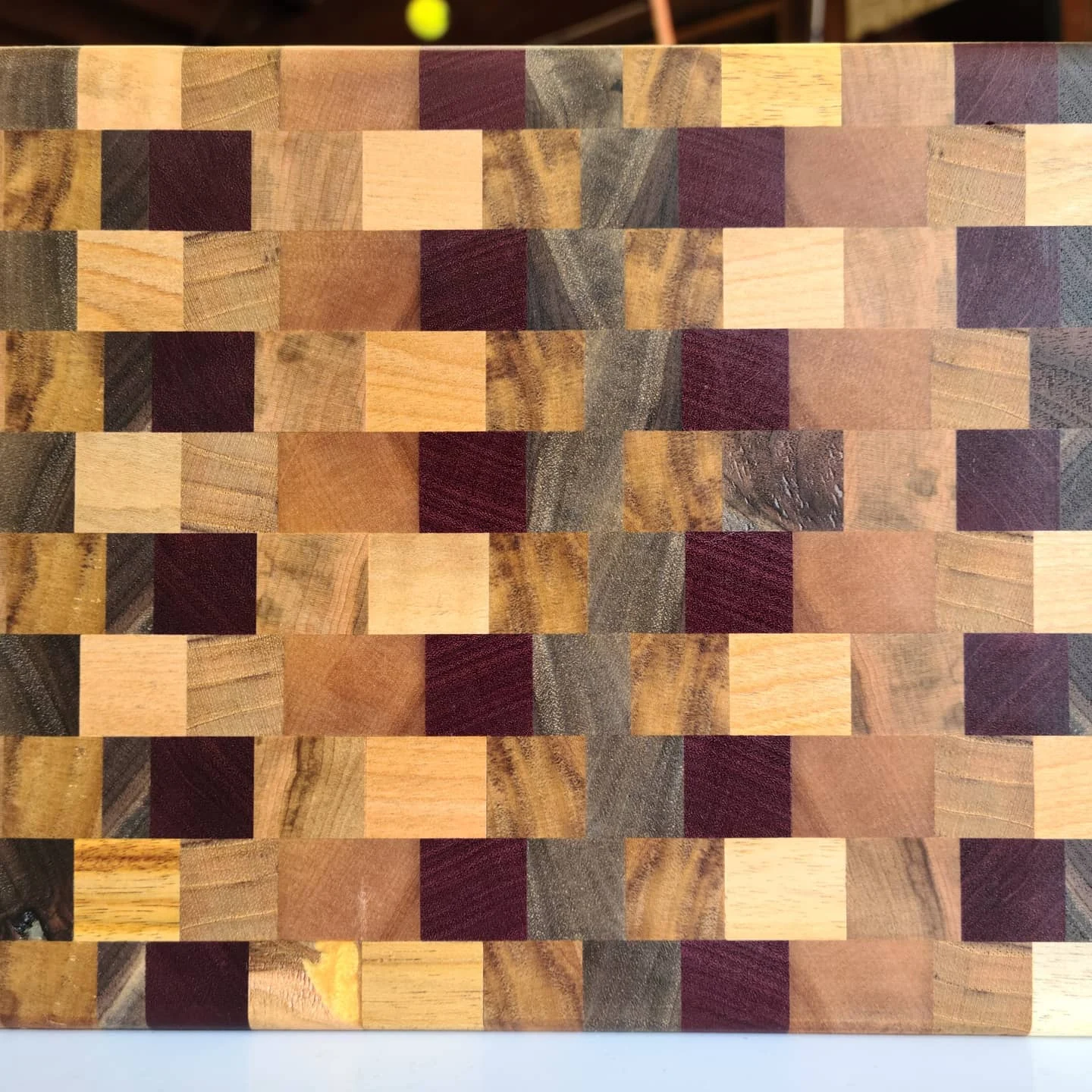 Close view of a mixed-color end-grain cutting-board pattern.