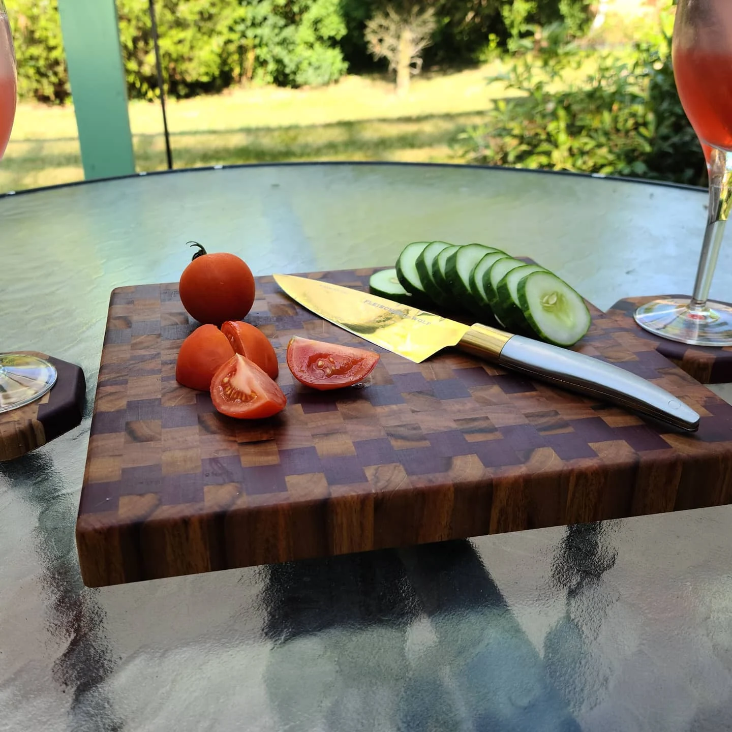 A mixed-wood end-grain board in use on an outdoor table.