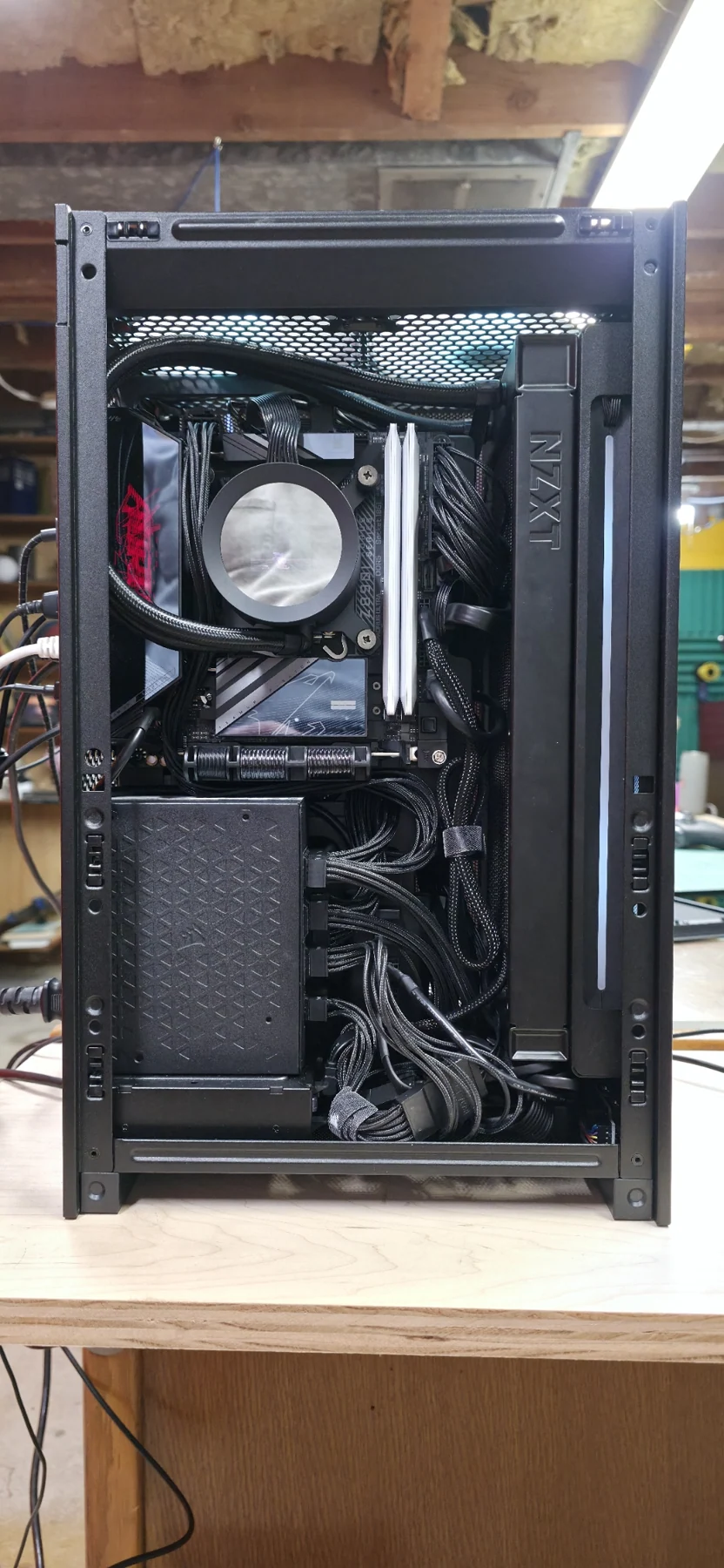 Motherboard side with the side panel removed: liquid-cooler pump, memory, radiator, power supply, and cabling.