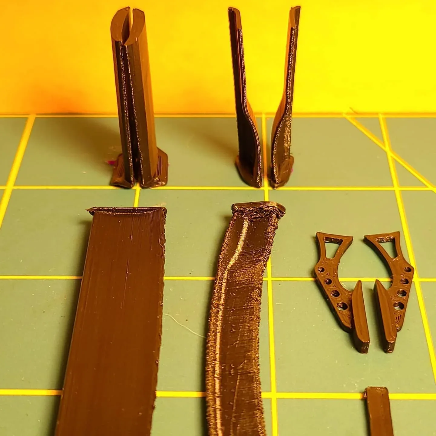 Small printed RC-spoiler pieces and trial orientations on a cutting mat.