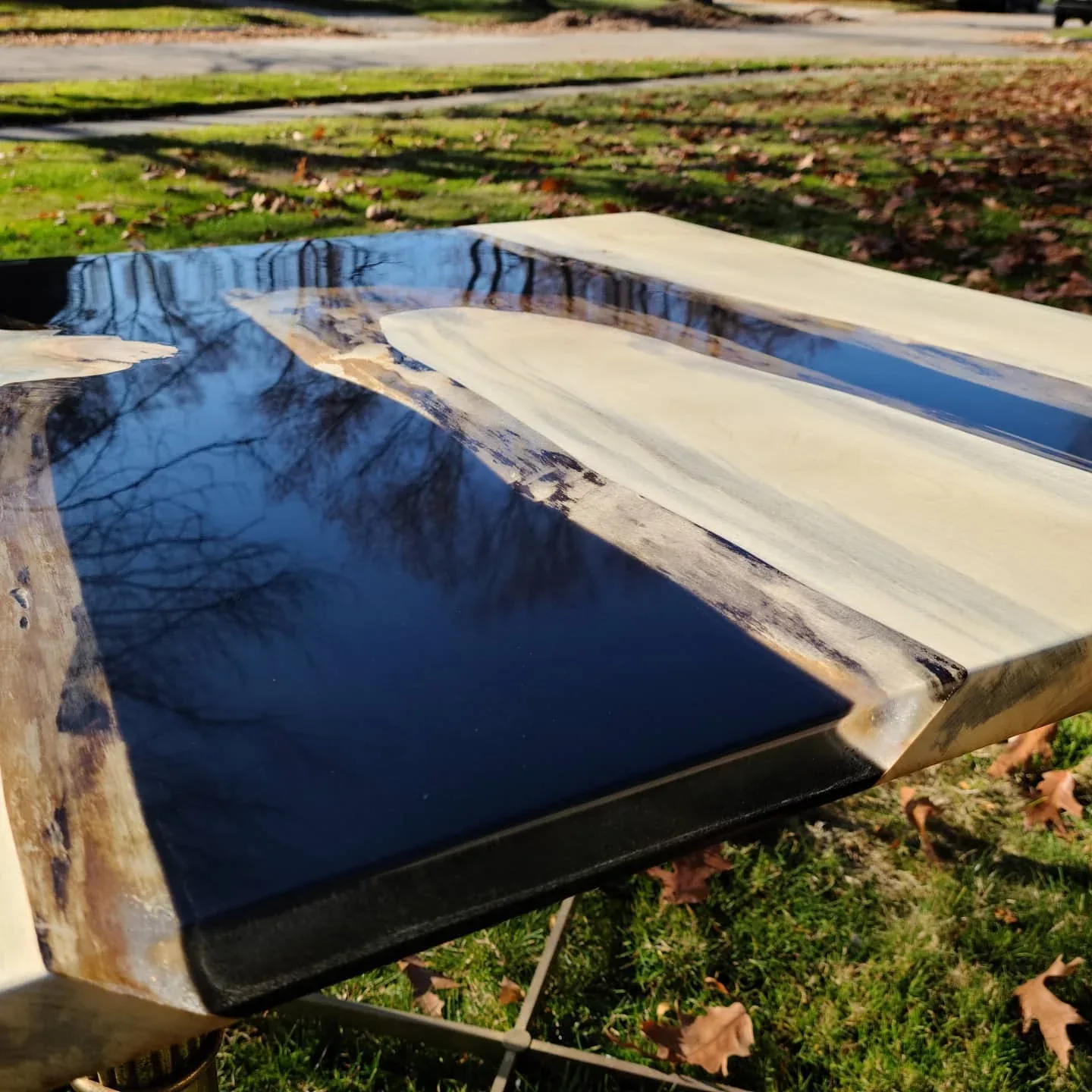 Cottonwood and dark resin tabletop photographed outdoors.