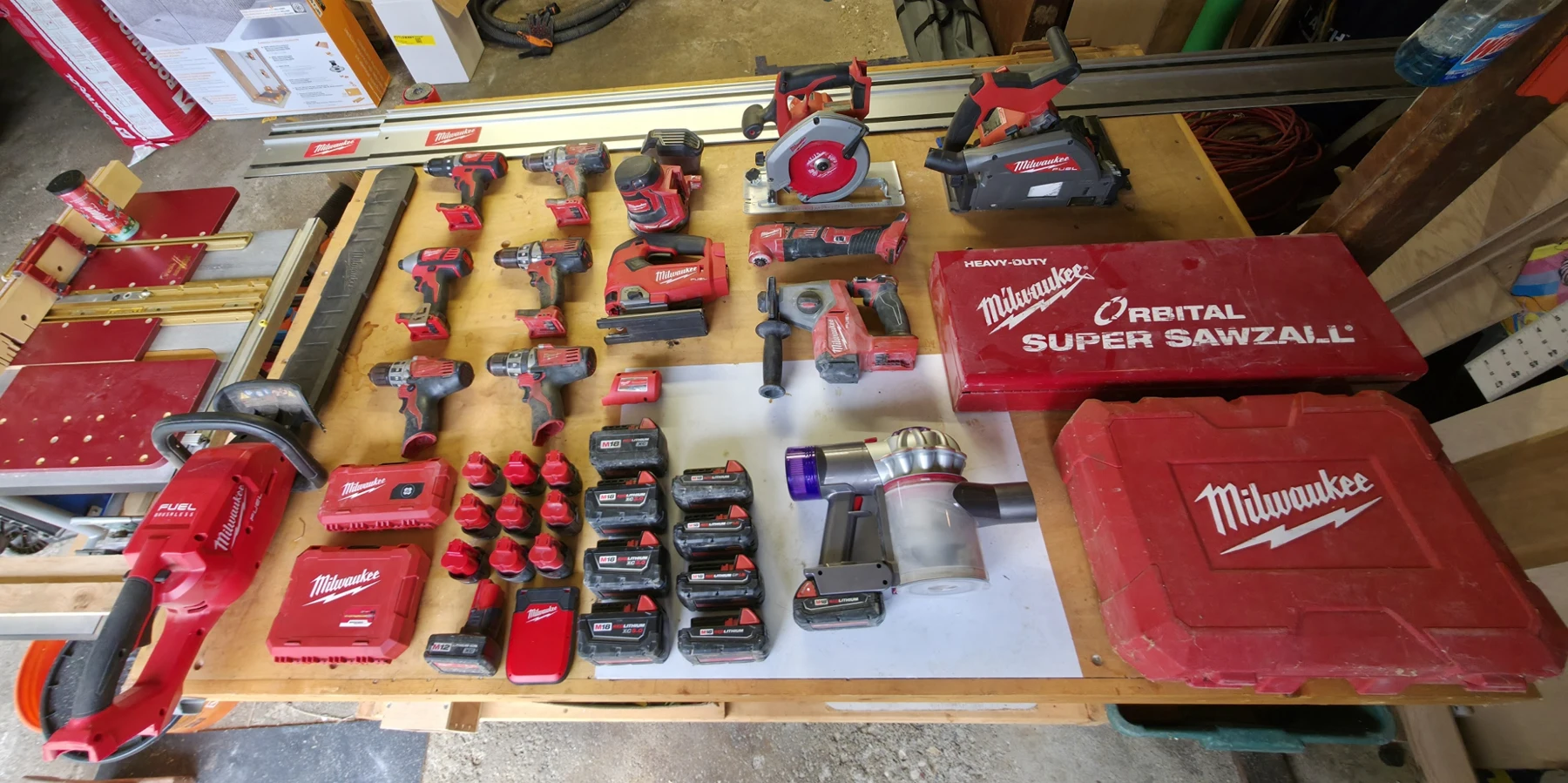 My Milwaukee collection and the M18-adapted Dyson laid out on the workbench.