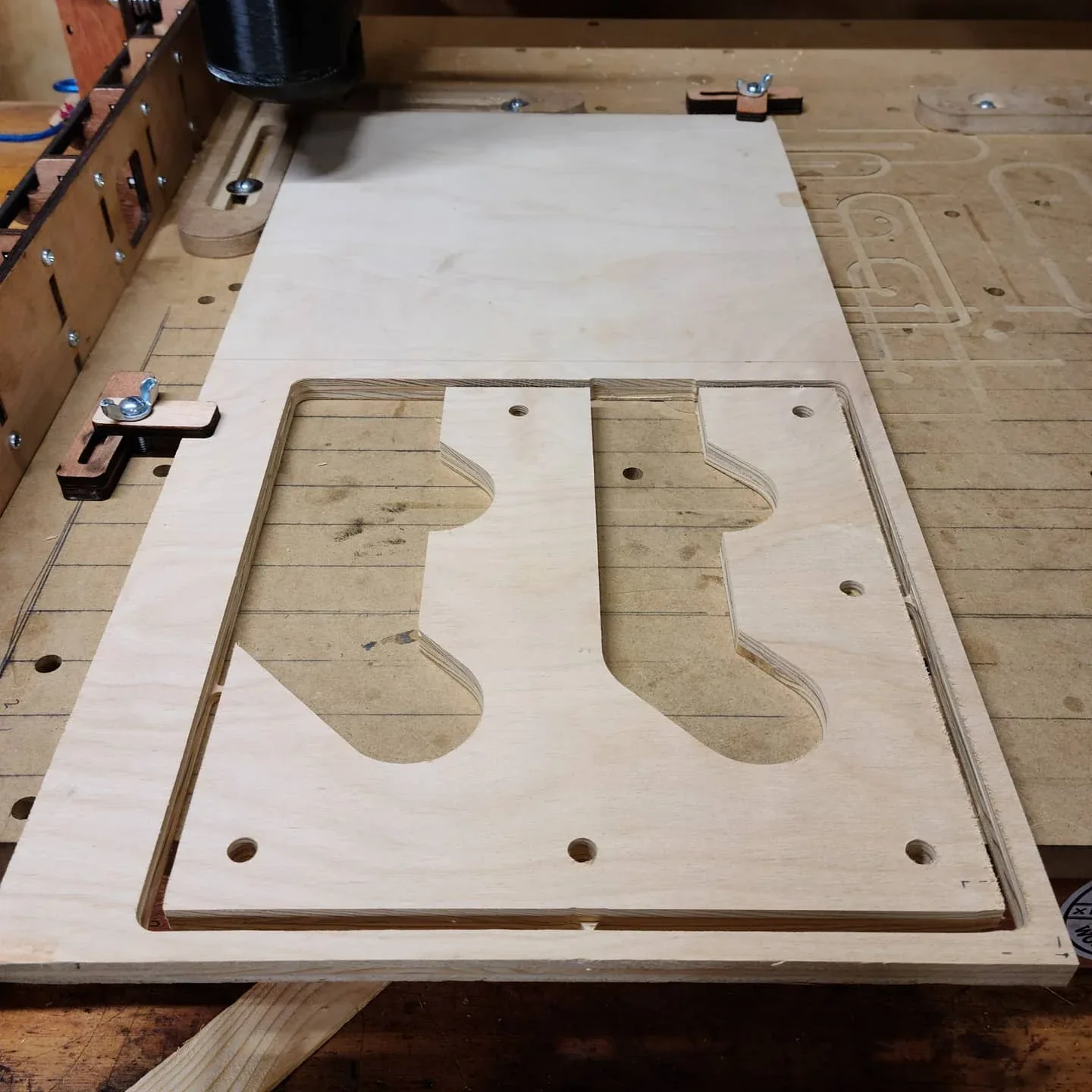 Wine-rack insert profiles cut from a plywood panel on the CNC.